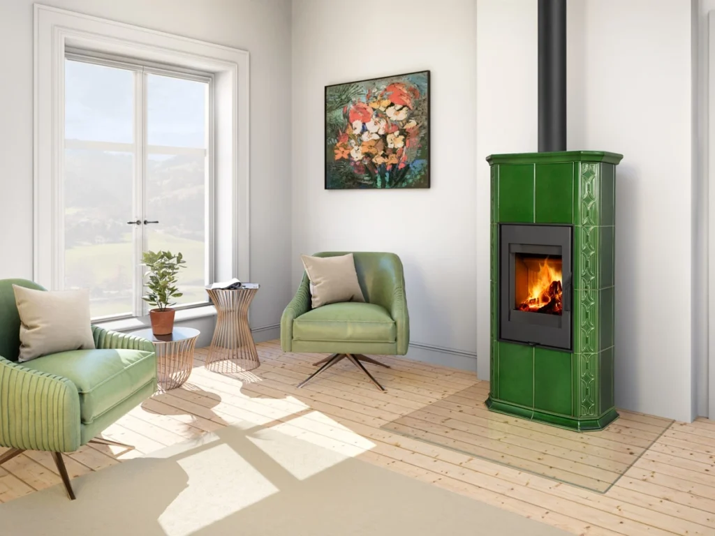 Kominek wolnostojący Romotop Gremio 4 w obudowie z zielonych kafli, z widocznym płomieniem i czarnym przewodem kominowym.